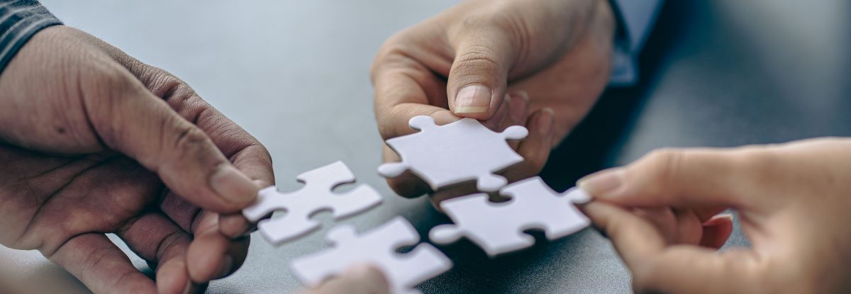 People holds in hand a jigsaw puzzle. Business solutions, success and strategy.Group of business people assembling jigsaw puzzle